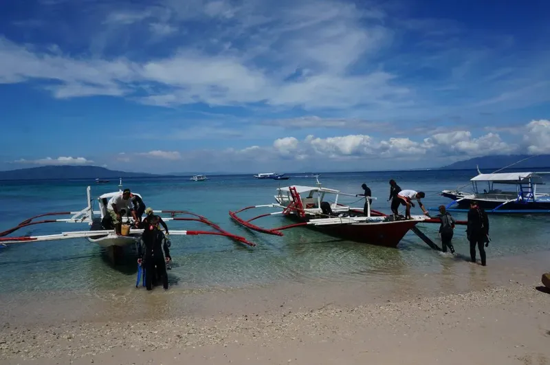 Plongée : des personnes montent à bord de bateaux sur une plage