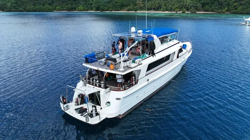 Bateau de plongée blanc avec des passagers et de l'équipement à bord