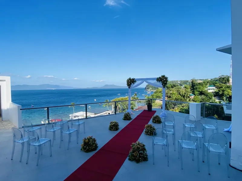 Terrasse avec vue mer, chaises transparentes et tapis rouge préparé