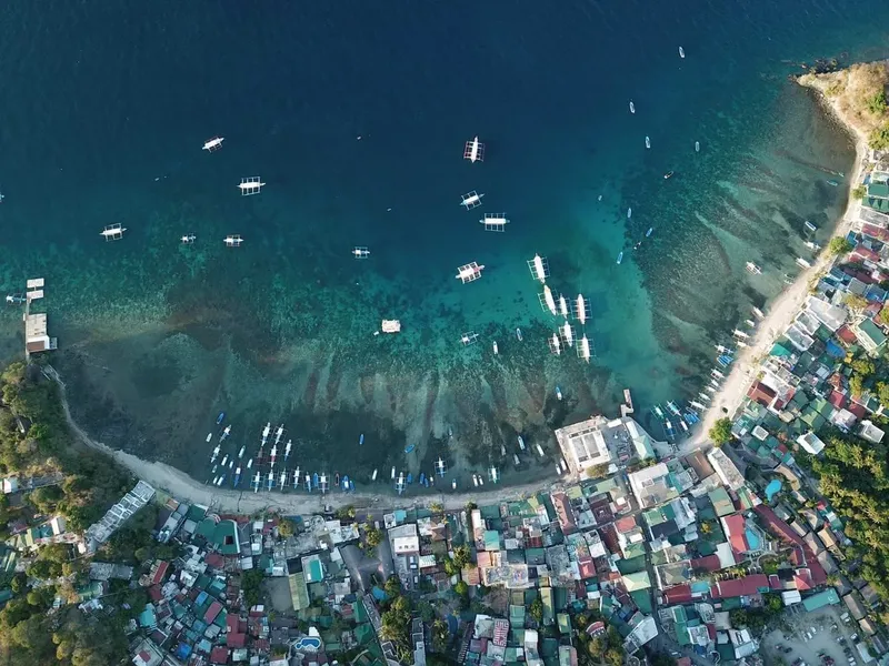 Vue aérienne d'une plage avec des bateaux et des bâtiments colorés