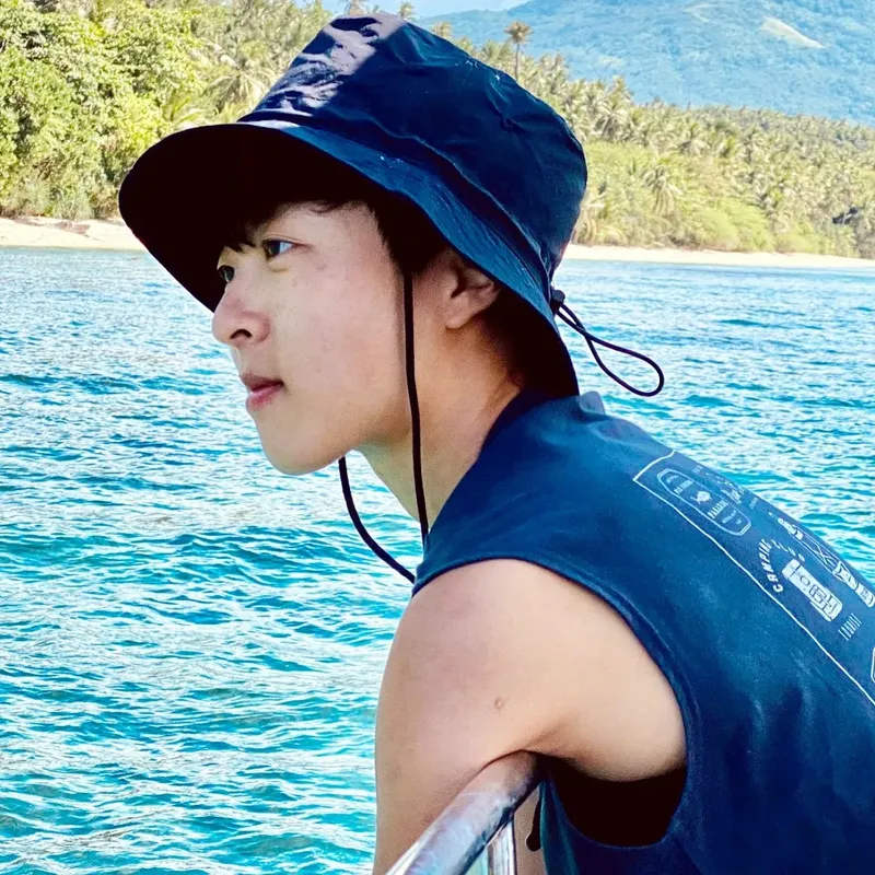 Jeune homme regardant au loin sur un bateau en mer