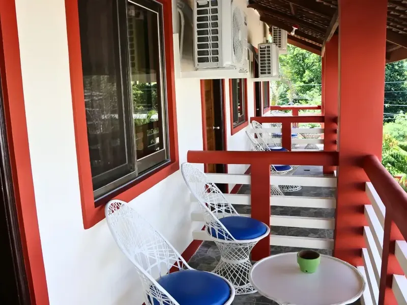 Terrasse avec mobilier blanc et bleu devant un bâtiment coloré