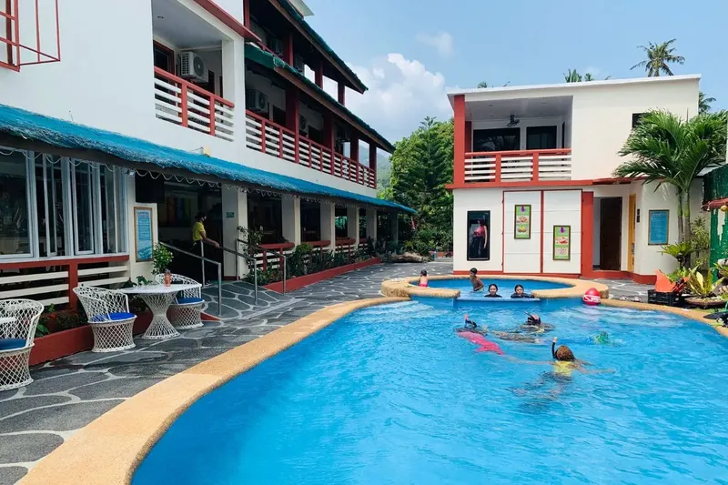 Bâtiments du centre de plongée avec des personnes dans une piscine