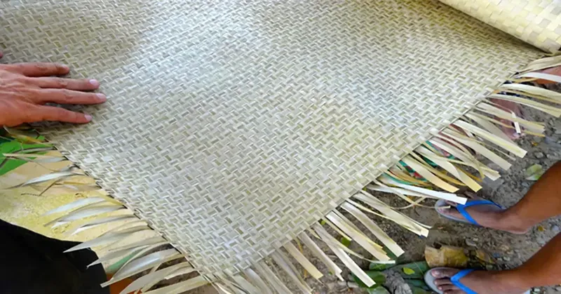 Mains et pieds sur un tissage de fibres naturelles claires