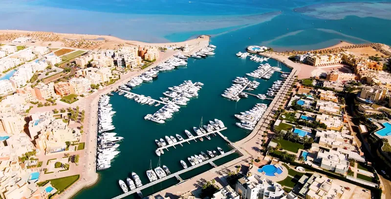 Marina avec de nombreux bateaux amarrés, bâtiments et eau turquoise