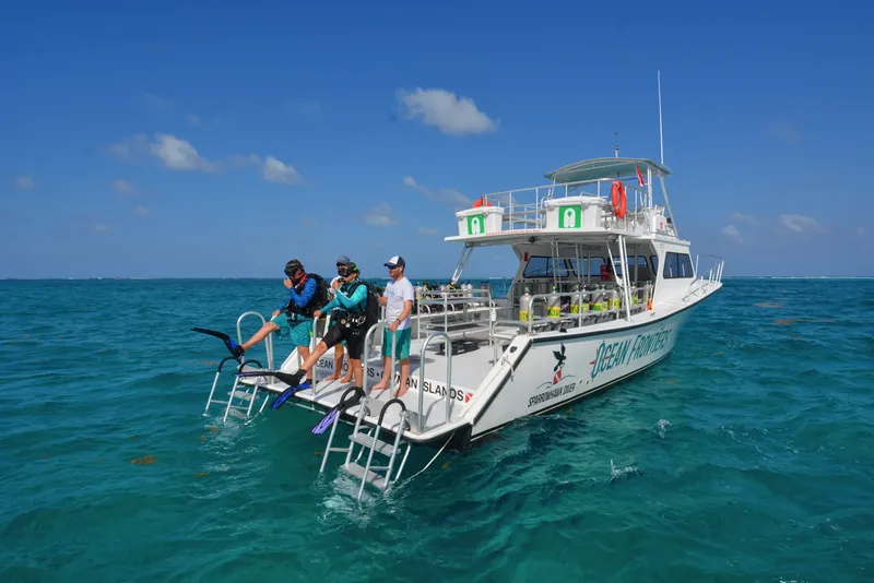 Plongeurs s'équipent sur un bateau de plongée en mer turquoise