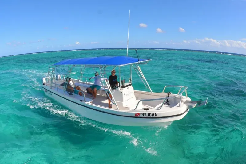 Bateau de plongée blanc avec passagers naviguant sur une mer turquoise