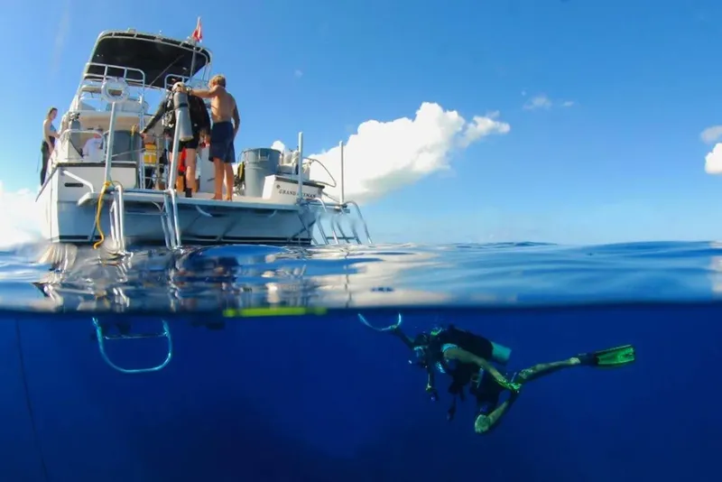 Plongeur en pleine immersion sous un bateau de croisière bleu ciel