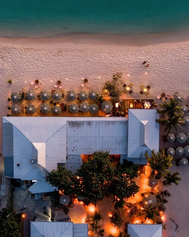 Vue aérienne d'un bâtiment blanc avec des transats sur la plage