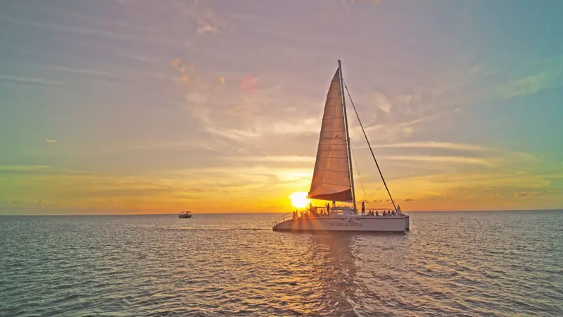 Catamaran en mer au coucher du soleil avec des passagers à bord