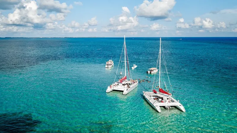 Catamarans ancrés dans une eau turquoise sous un ciel nuageux