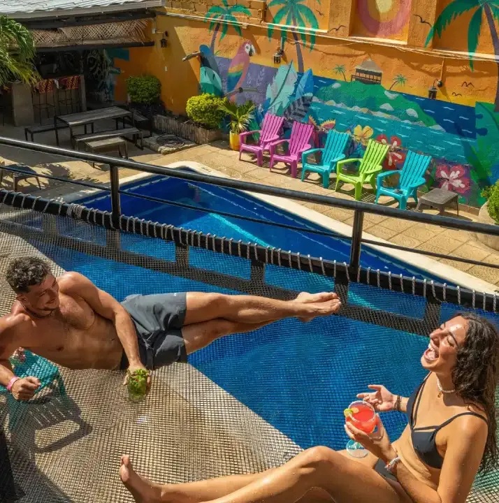 Deux personnes sourient et se détendent au bord d'une piscine colorée