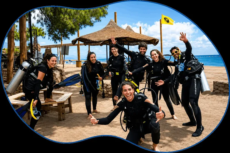 Groupe de plongeurs souriants en combinaison, équipement complet, pose joyeuse