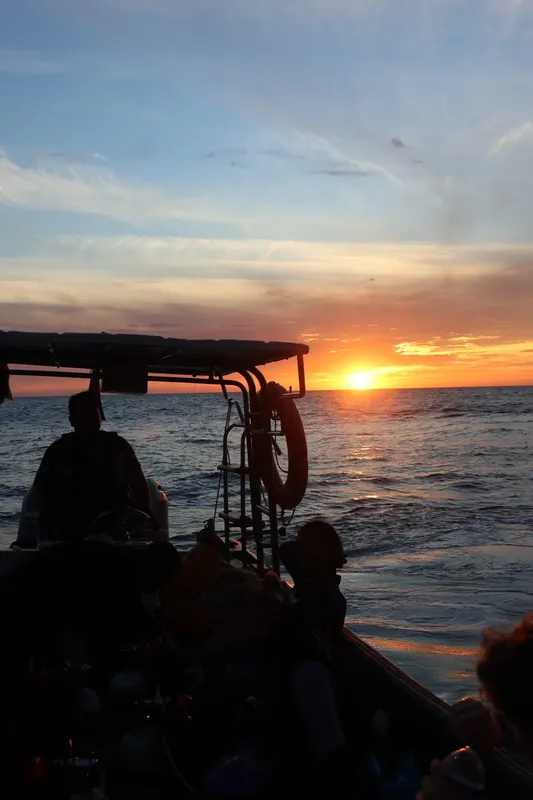 Coucher de soleil en mer depuis un bateau de plongée avec des passagers