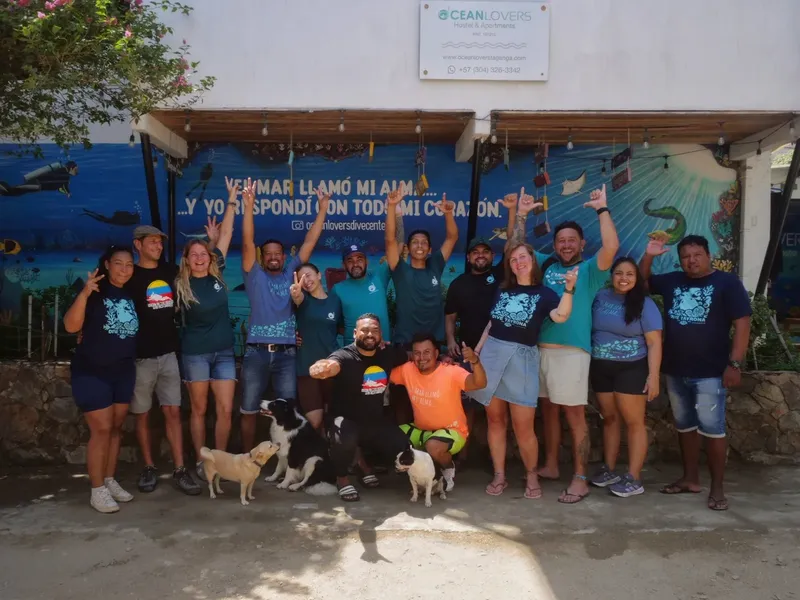 Groupe de personnes souriantes devant une fresque marine et un centre