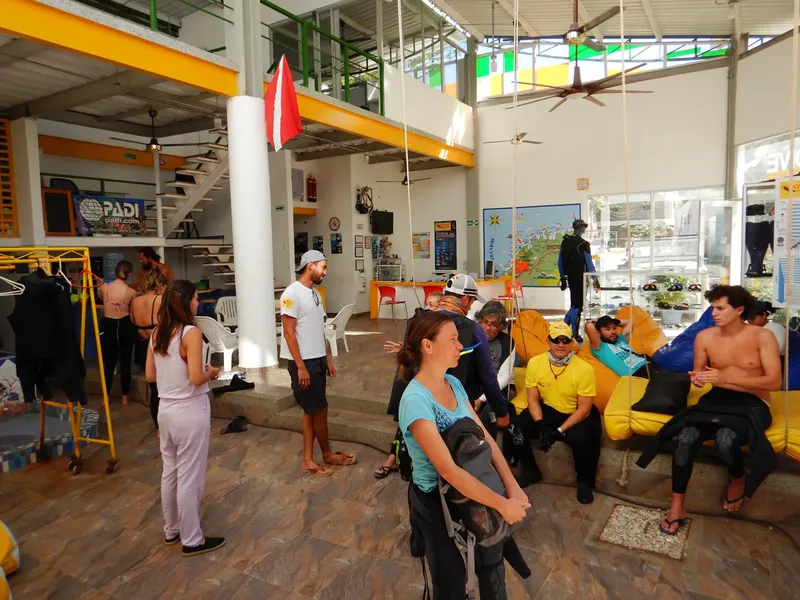 Intérieur d'un centre de plongée avec des personnes et du matériel