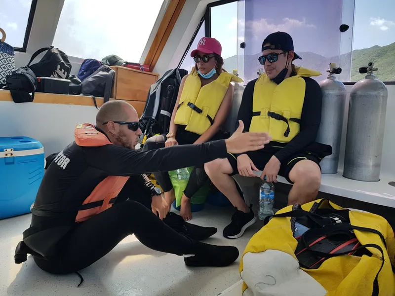 Instructeur expliquant les consignes de sécurité à des plongeurs sur un bateau