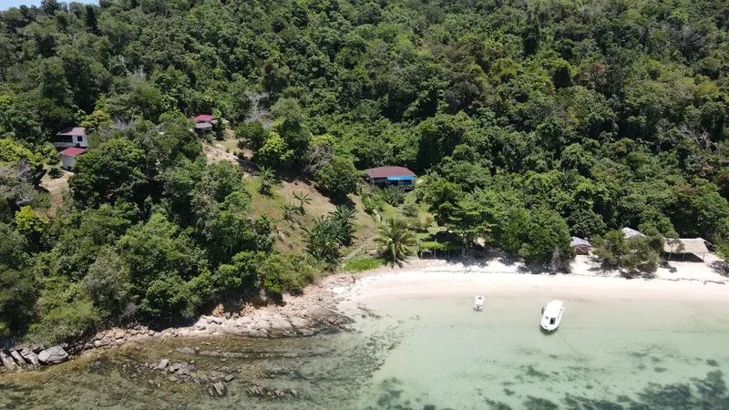 Vue aérienne d'une plage avec des bâtiments et des bateaux amarrés
