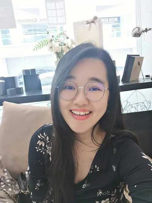 Portrait d'une jeune femme souriante avec des lunettes rondes