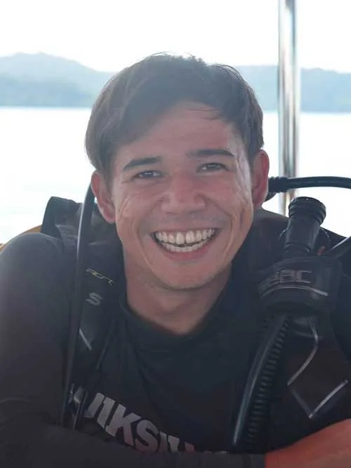 Plongeur souriant portant son équipement sur un bateau en mer