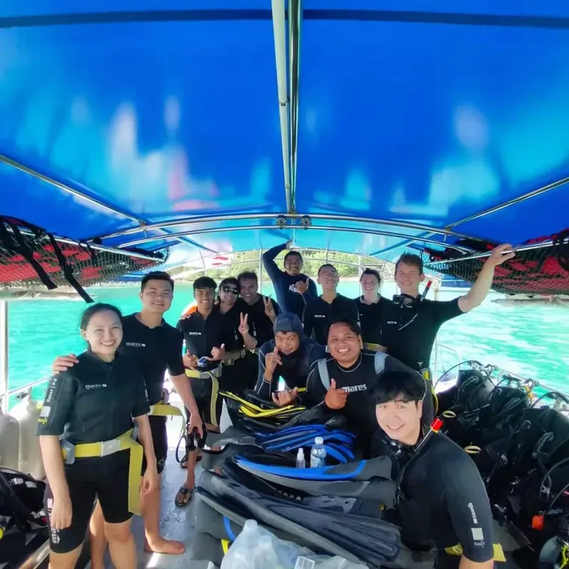 Groupe de plongeurs souriants à bord d'un bateau de plongée en mer