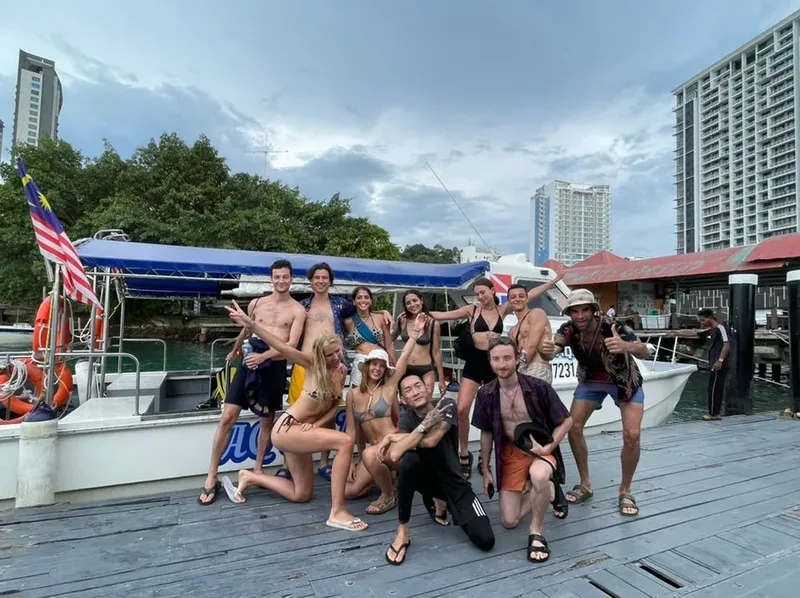 Groupe de personnes souriantes posant sur un ponton devant des bateaux