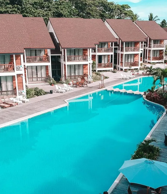 Vue aérienne d'une piscine turquoise et de bâtiments avec balcons