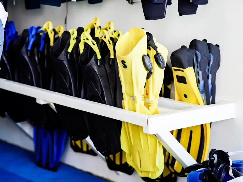 Rangées de palmes de plongée noires et jaunes sur étagère blanche