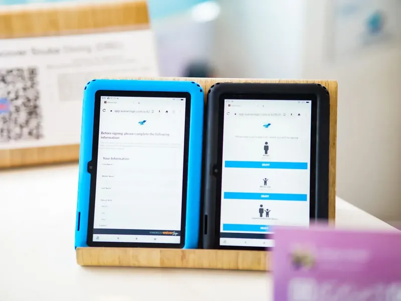 Deux tablettes numériques affichent des formulaires et des options de signature