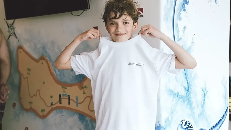 Un jeune garçon souriant tire sur son t-shirt de plongée