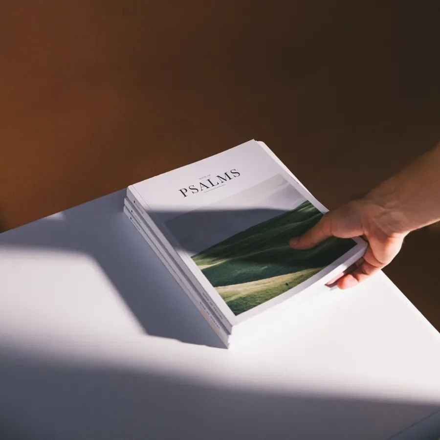 Main tenant un livre blanc sur une surface claire éclairée