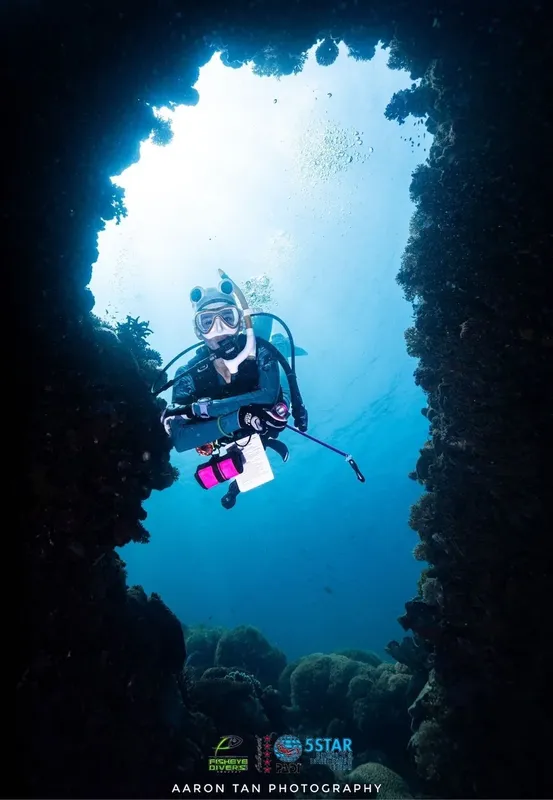 Plongeur explorant une grotte sous-marine avec une lumière naturelle