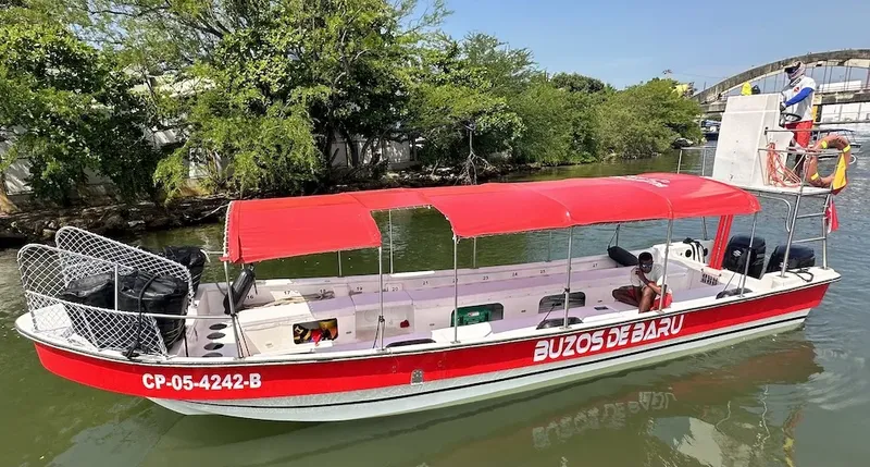 Bateau rouge amarré avec des passagers et un auvent protecteur
