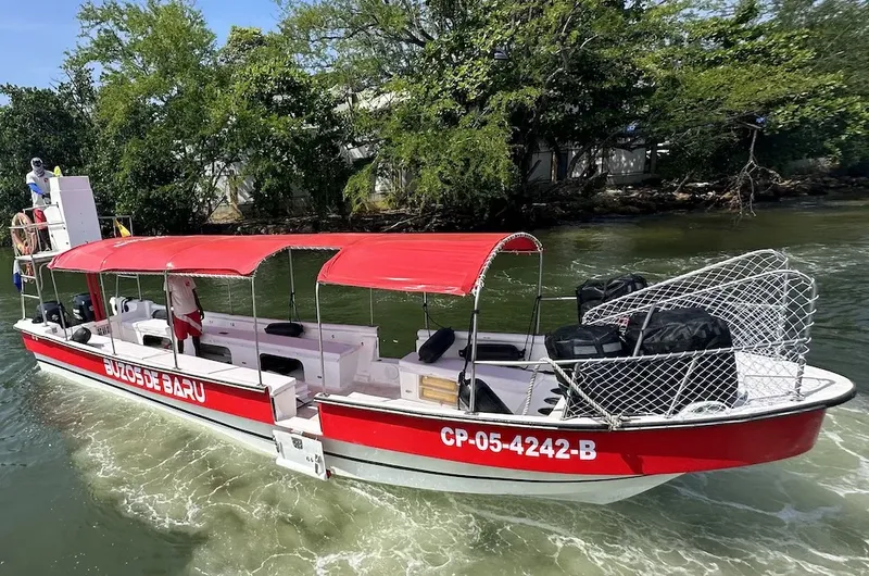 Bateau rouge avec passagers naviguant sur une eau calme et verte