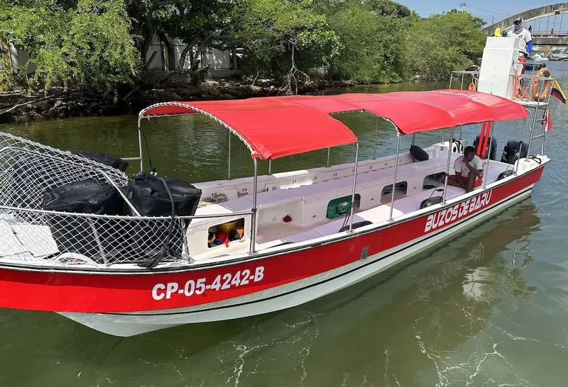 Bateau de plongée blanc et rouge amarré sur l'eau calme