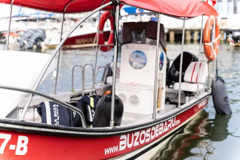 Bateau de plongée rouge amarré à quai avec son site web visible