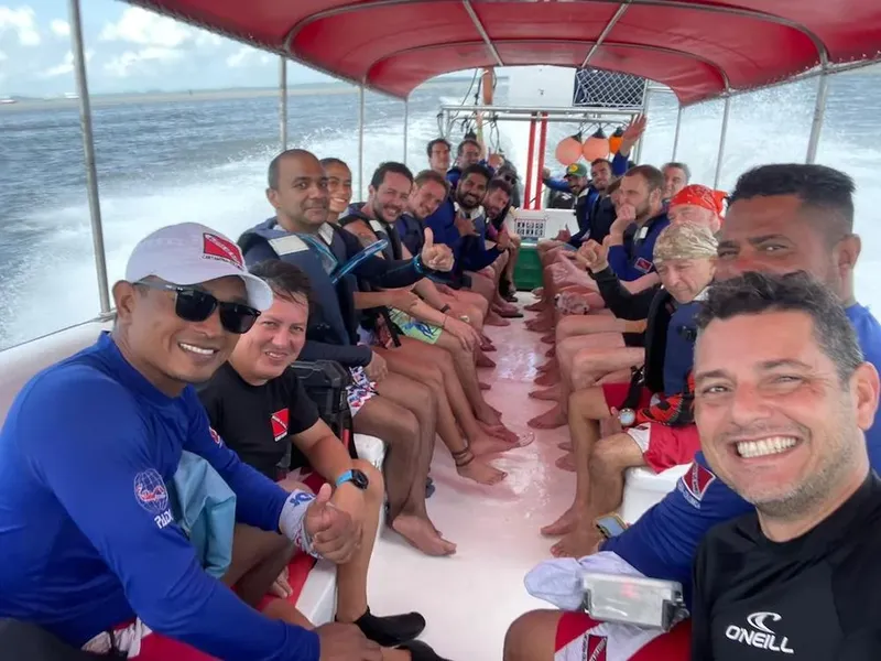 Groupe de plongeurs souriants à bord d'un bateau en mer