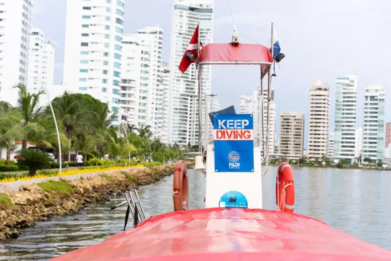 Bateau de plongée rouge avec drapeaux et logo PADI en vue frontale