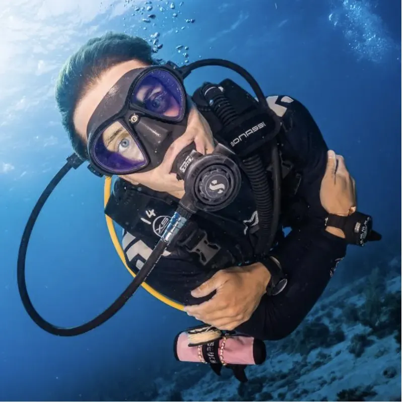 Plongeur en pleine immersion, équipé, vue du dessus, eau bleue