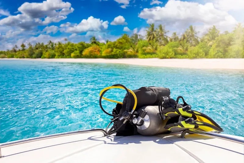 Equipement de plongée sur un bateau en mer, plage tropicale en arrière-plan
