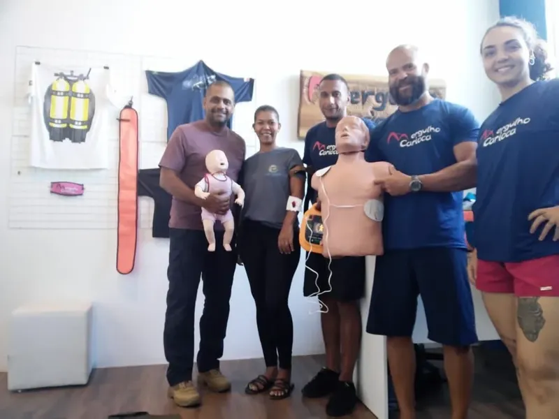 Groupe de personnes posant avec des mannequins de premiers secours et du matériel