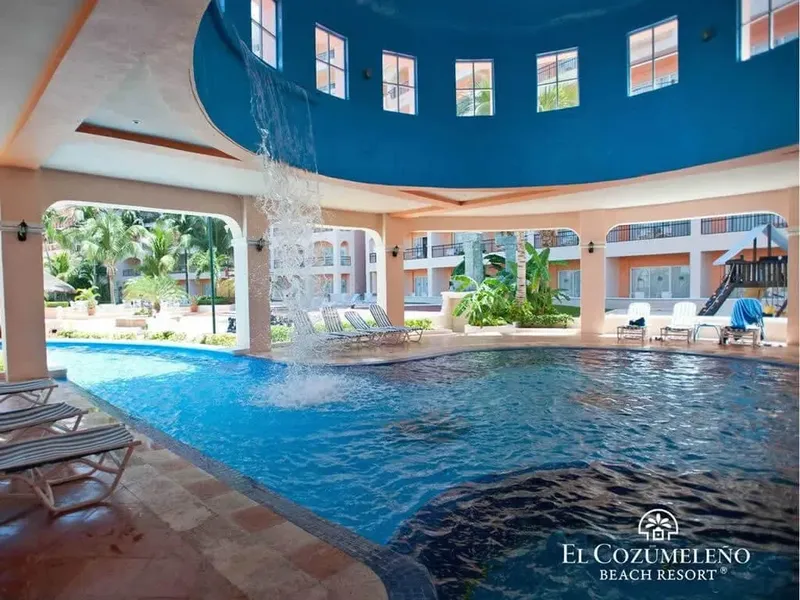 Piscine d'hôtel avec cascade et architecture intérieure lumineuse