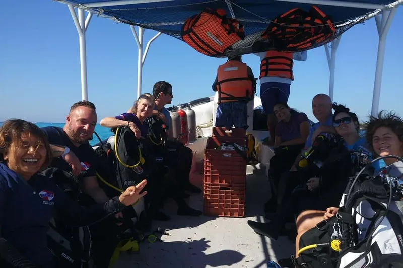 Groupe de plongeurs souriants à bord d'un bateau de plongée ensoleillé