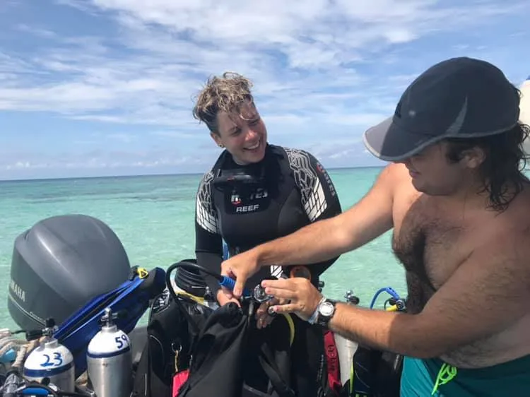 Deux plongeurs sur un bateau préparent leur équipement de plongée