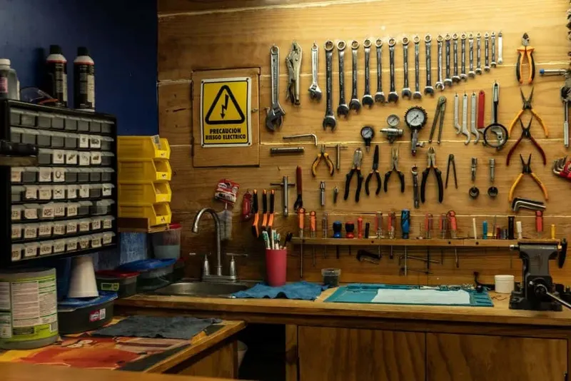 Atelier de réparation avec outils, avertissement danger électricité, plan de travail