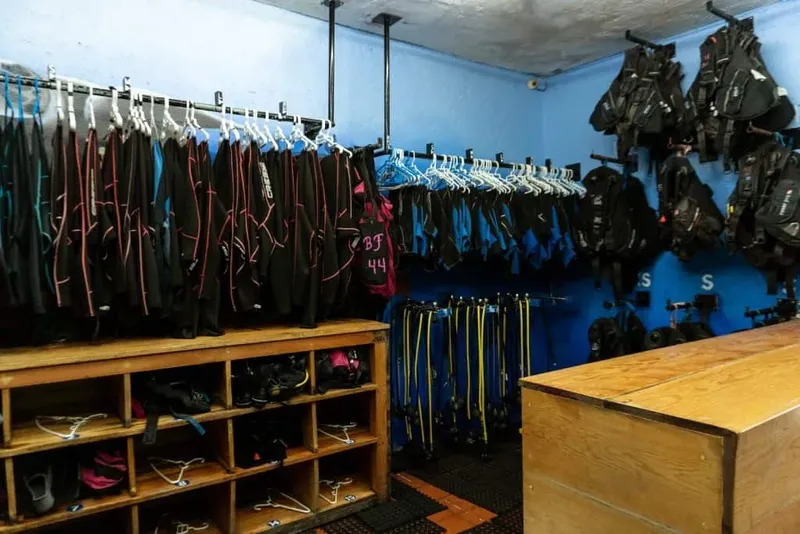 Vestiaire d'un centre de plongée avec combinaisons et équipements rangés