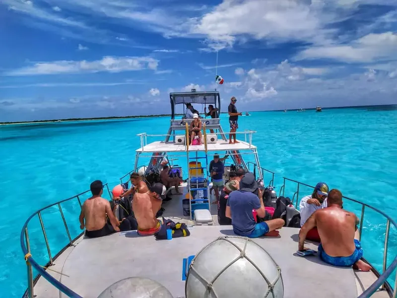 Plongée : groupe de personnes sur un bateau en direction du site