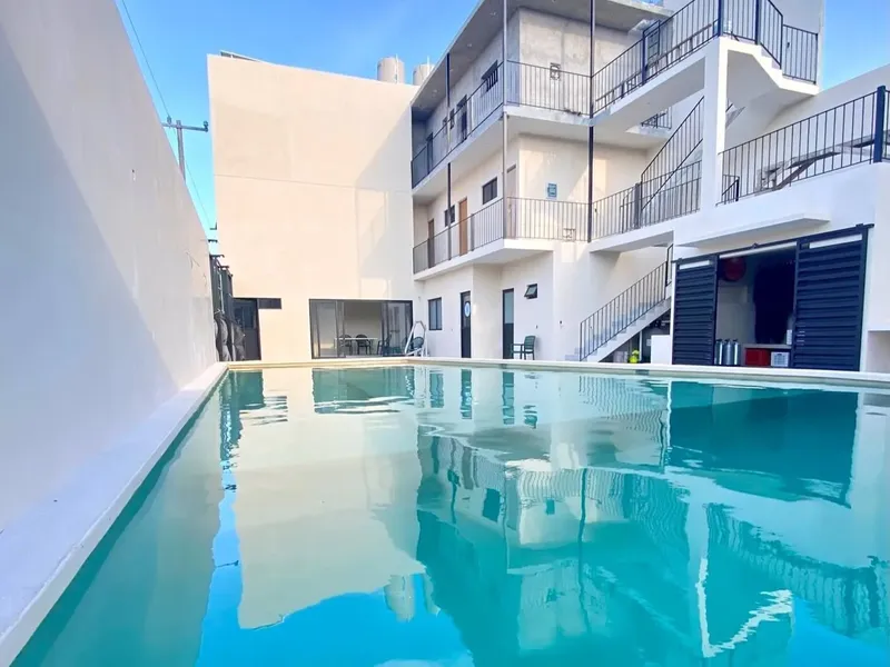 Bâtiment blanc avec piscine turquoise reflétant l'architecture moderne