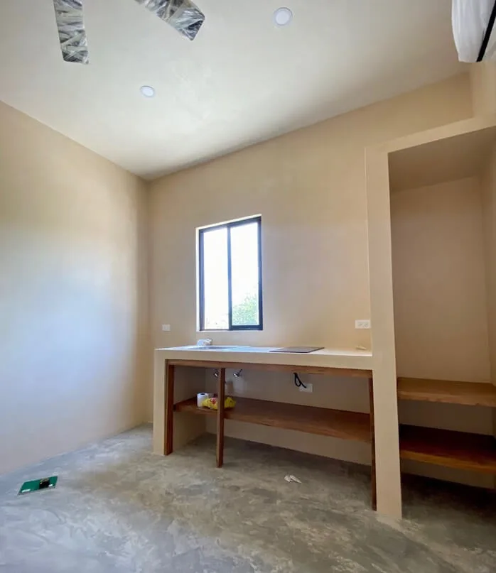 Interieur d'une piece nue avec une fenetre et un comptoir en bois