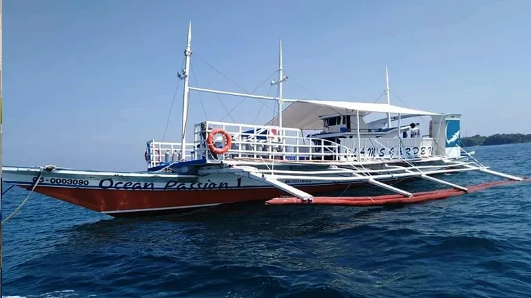 Bateau de plongée coloré naviguant sur une mer bleue calme